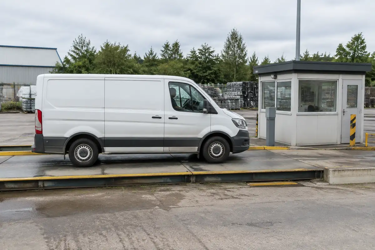 Utilitaire montant sur une bascule publique à l'entrée d'une zone d'activité