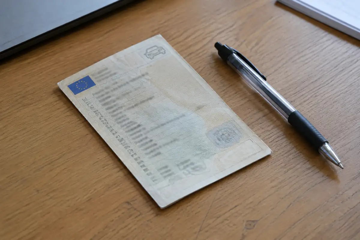 Certificat d'immatriculation posé sur un bureau à côté d'un stylo