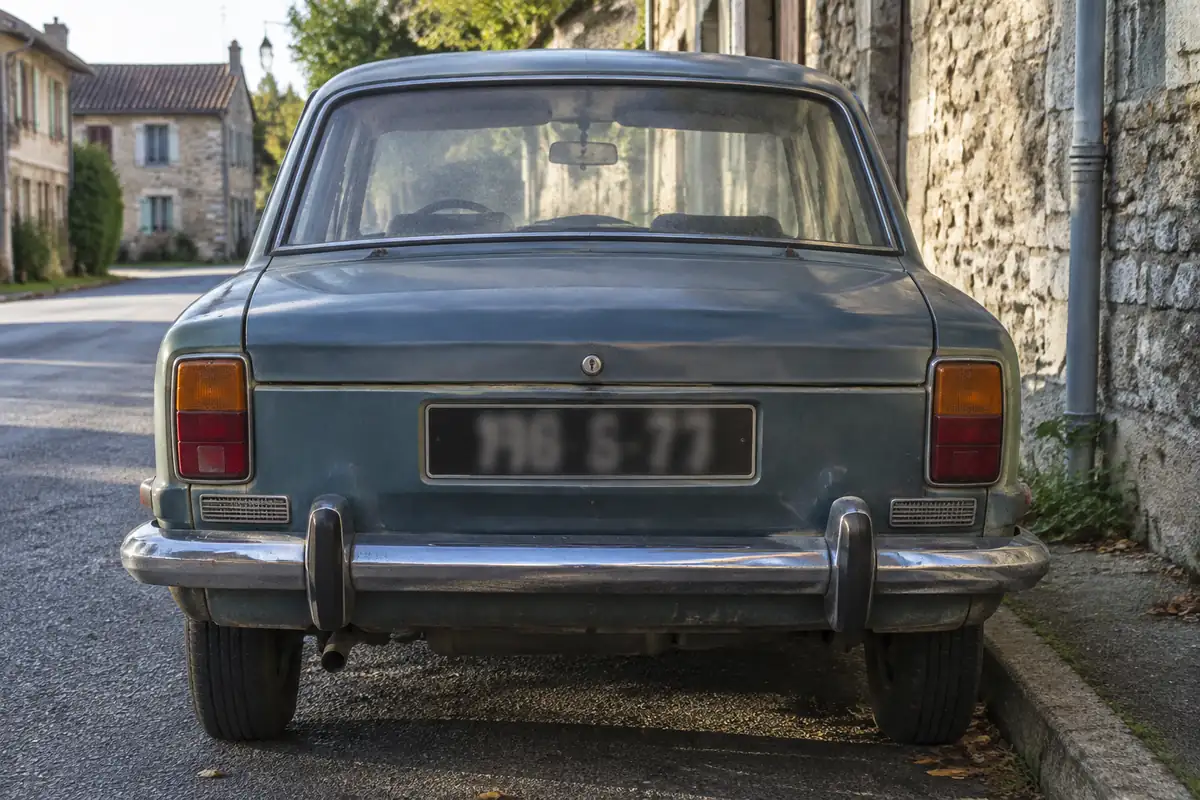 Arrière d'une voiture des années 1970 avec plaque noire à caractères blancs