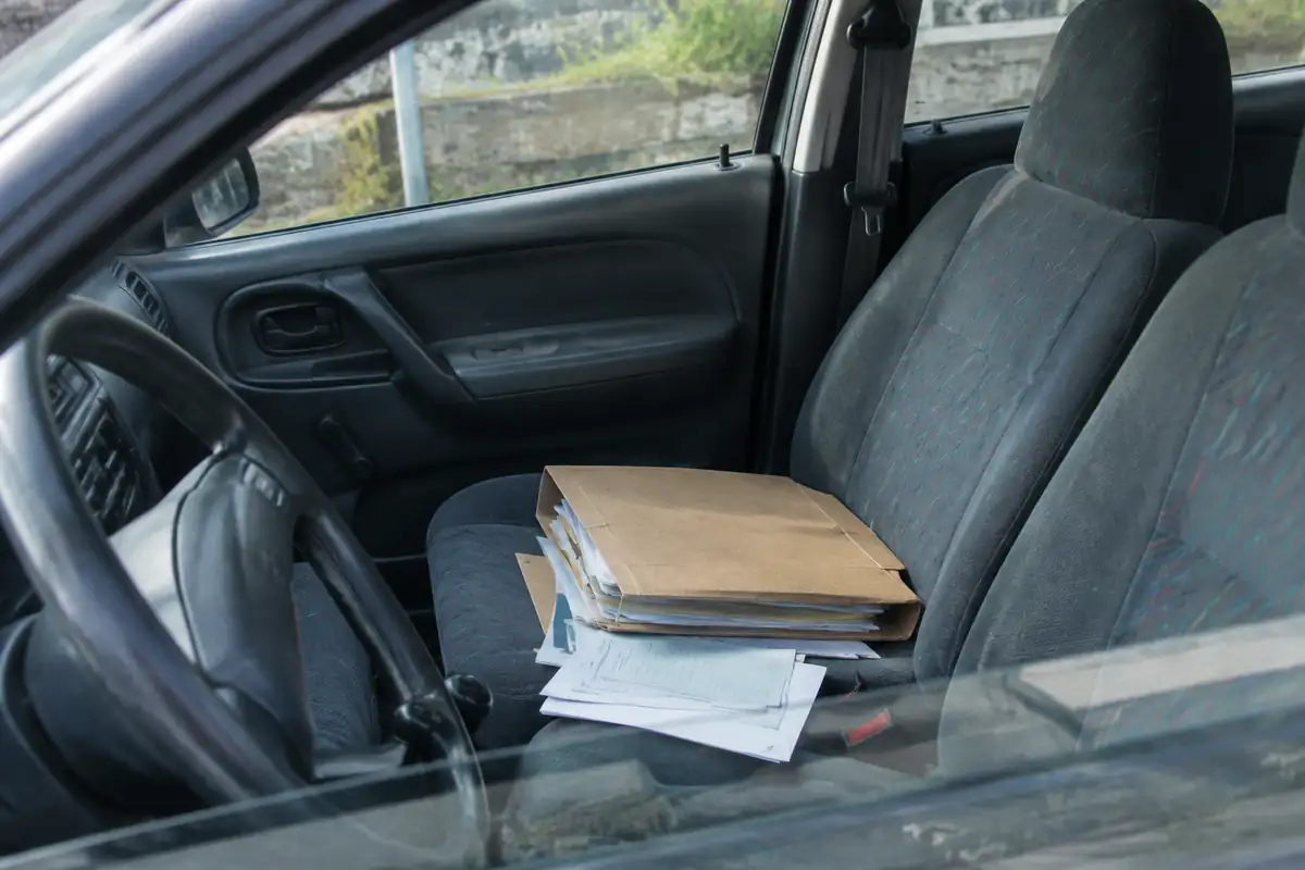 Chemise de documents administratifs posée sur le siège avant d'une voiture